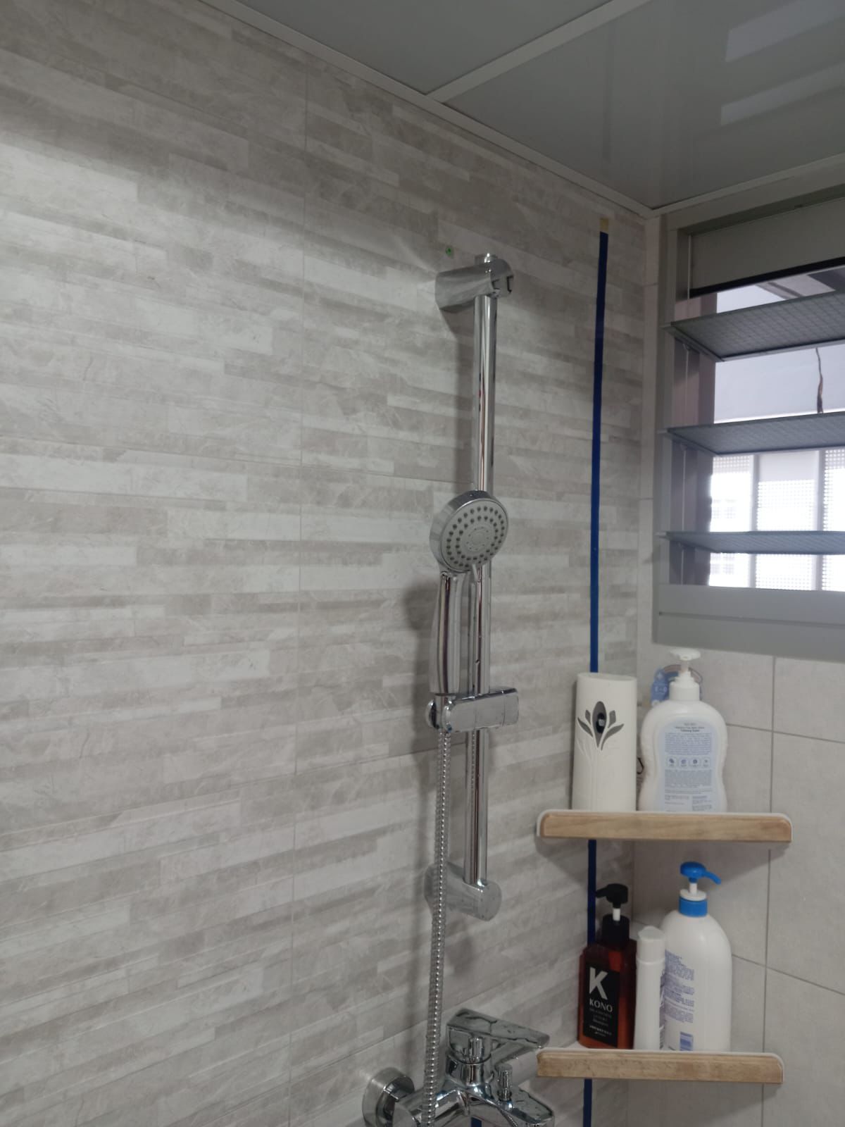 Chrome shower rail set newly installed in a tiled bathroom
